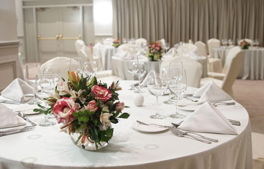 Formal gala dinner tables with glassware and centrepieces in a banquet hall
